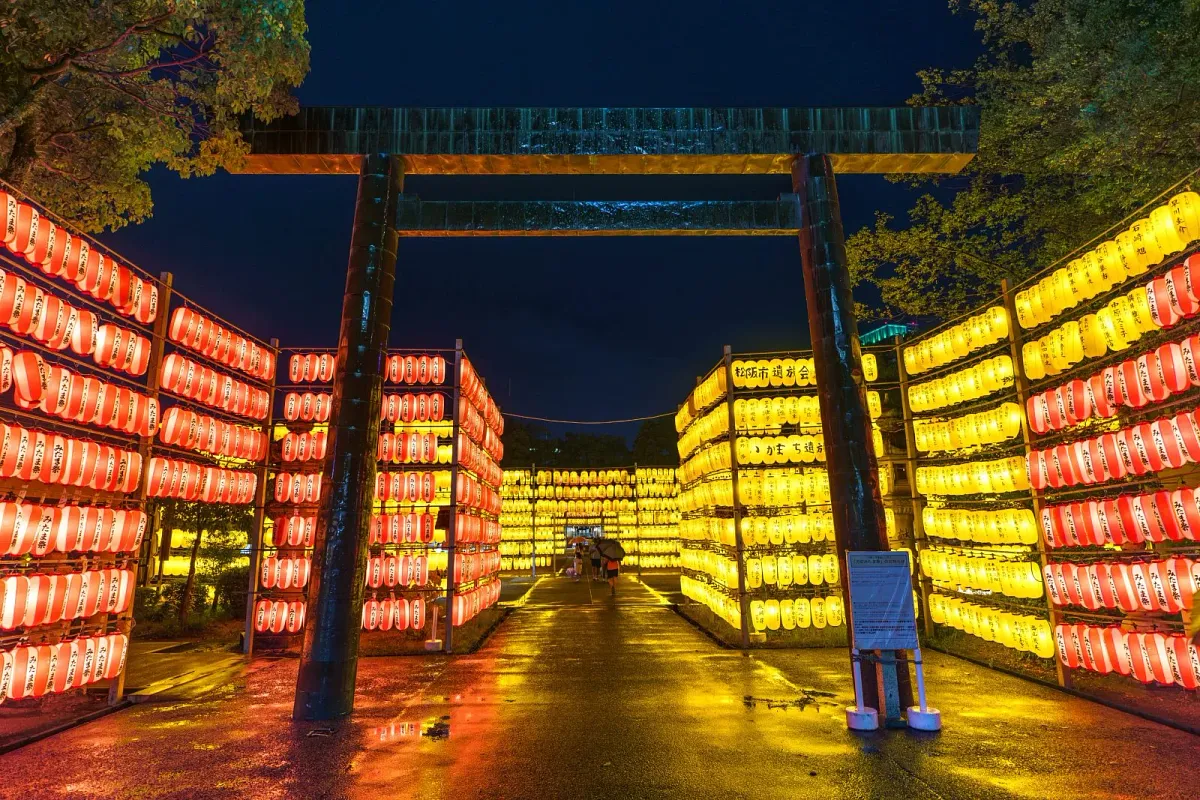 雨で濡れた境内の万灯みたま祭。参道に映る提灯も幻想的